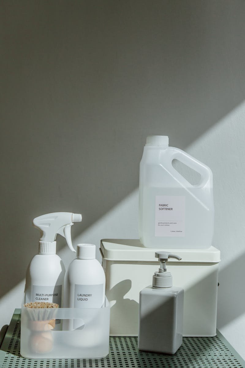 Elegant arrangement of cleaning products with natural sunlight casting shadows, highlighting a minimalist aesthetic.