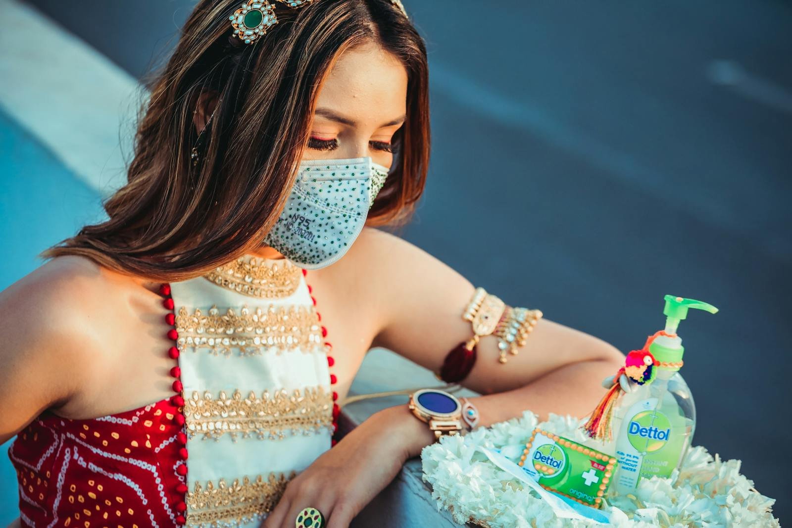 A woman in traditional Indian dress wearing a mask with hygiene products.