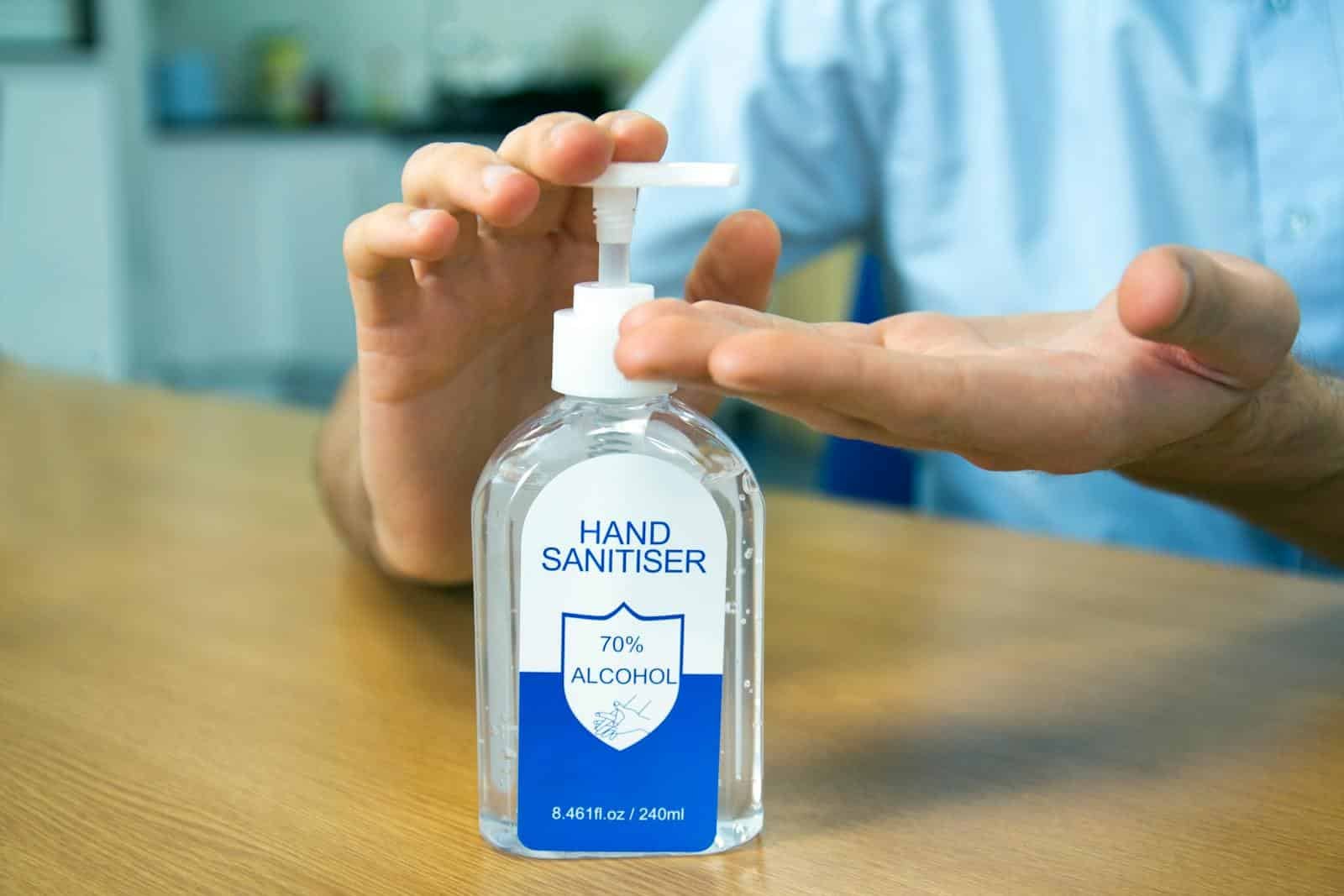 Close-up of hands using 70% alcohol hand sanitizer for hygiene.