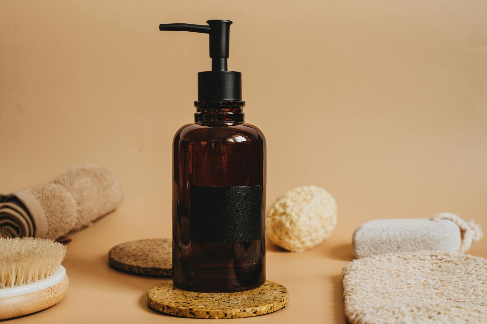 An elegant arrangement of spa essentials featuring a brown amber pump bottle for premium skincare.