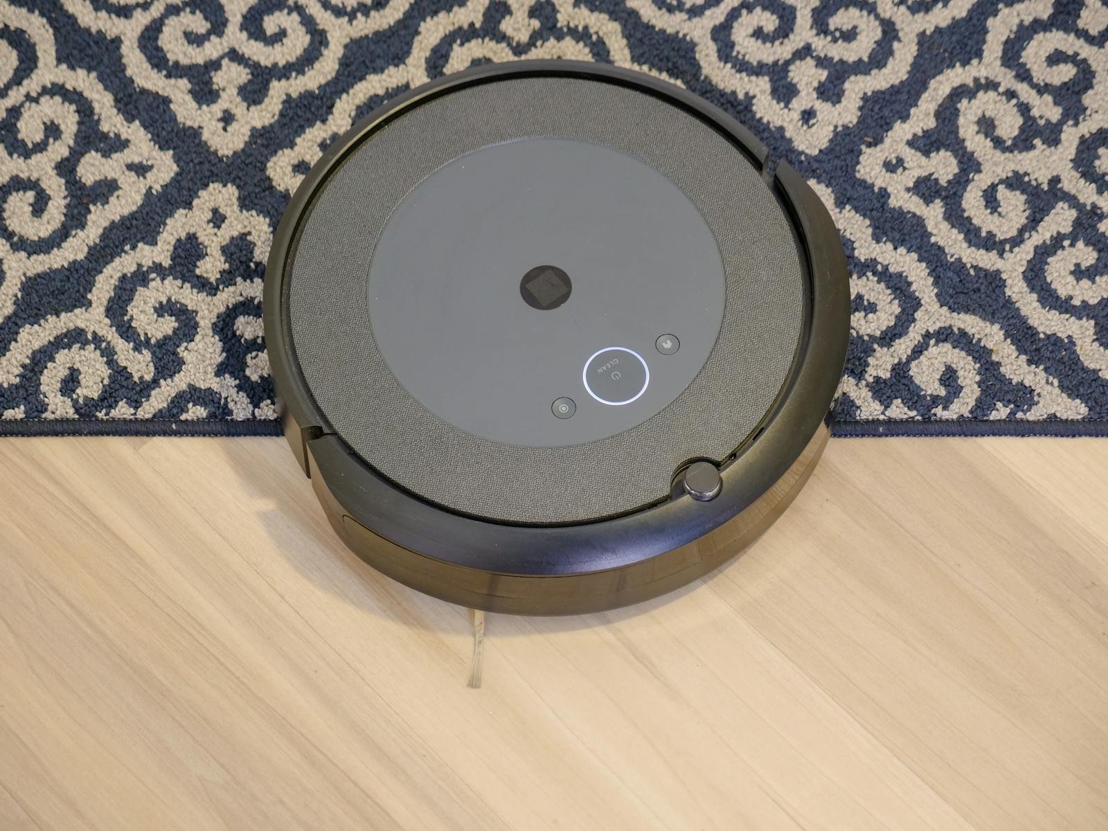 Modern robotic vacuum cleaner on a patterned carpet for efficient cleaning.