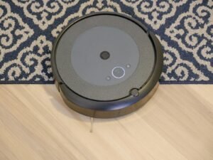 Modern robotic vacuum cleaner on a patterned carpet for efficient cleaning.