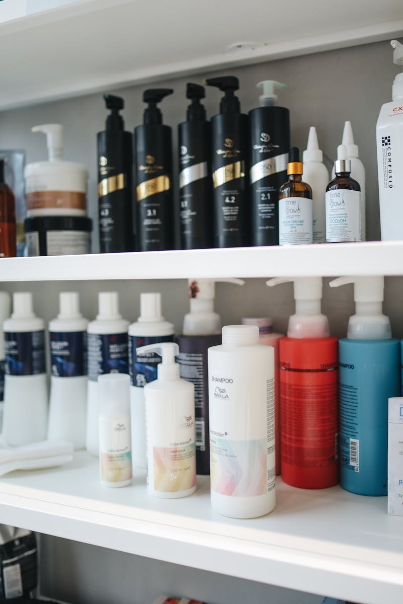 Variety of shampoos and conditioners displayed neatly on a shelf, ideal for beauty and haircare themes.